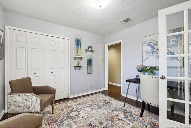 sitting room with a textured ceiling and hardwood / wood-style flooring