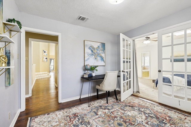 entryway with ceiling fan, dark hardwood / wood-style flooring, a textured ceiling, and french doors