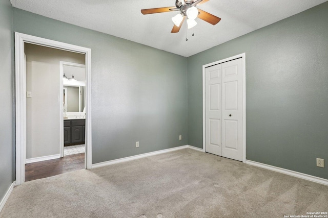 unfurnished bedroom featuring carpet, a textured ceiling, a closet, and ceiling fan