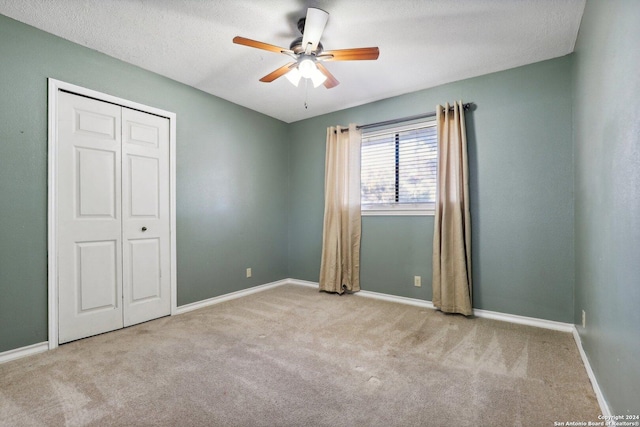 unfurnished bedroom with ceiling fan, light carpet, and a closet