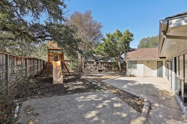 view of yard featuring a playground and a patio