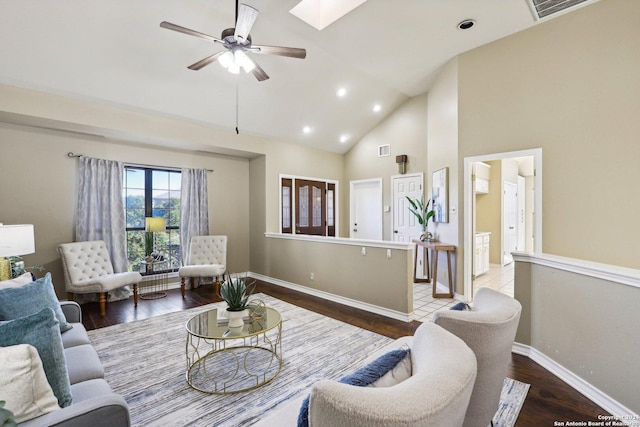 living room with a skylight, ceiling fan, high vaulted ceiling, and hardwood / wood-style flooring