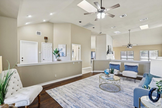 living area with a skylight, dark hardwood / wood-style floors, high vaulted ceiling, and ceiling fan