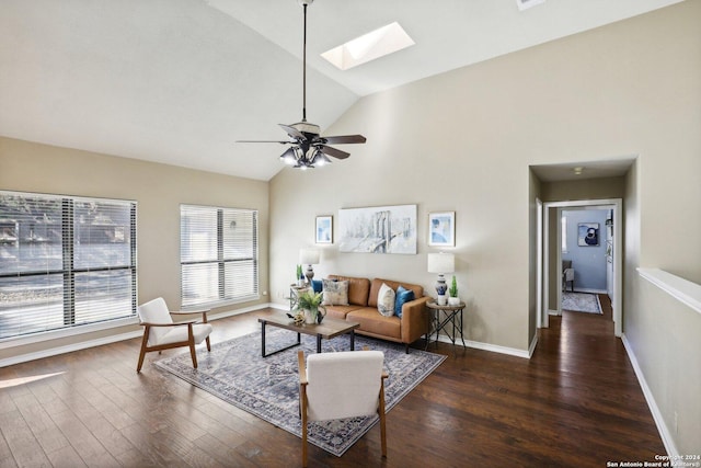 living room with a skylight, ceiling fan, dark hardwood / wood-style flooring, and high vaulted ceiling