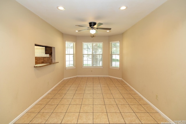 tiled spare room with ceiling fan