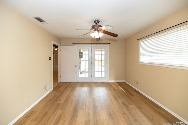 spare room with ceiling fan, light hardwood / wood-style flooring, and french doors