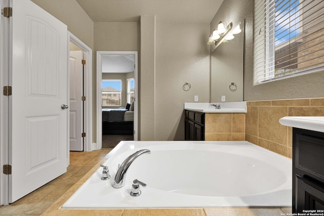 bathroom featuring tile patterned floors, vanity, and a washtub