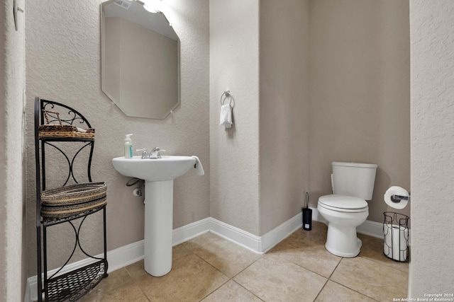 bathroom featuring tile patterned flooring, toilet, and sink