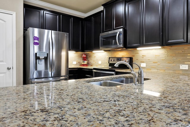 kitchen featuring light stone countertops, decorative backsplash, stainless steel appliances, and crown molding