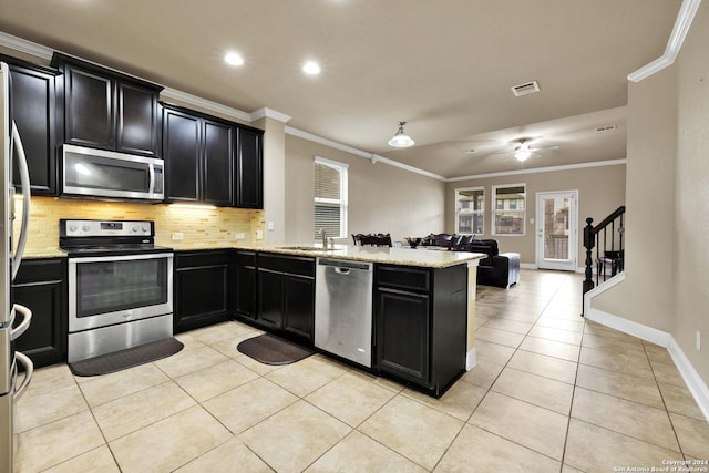 kitchen featuring sink, stainless steel appliances, kitchen peninsula, light tile patterned floors, and ornamental molding