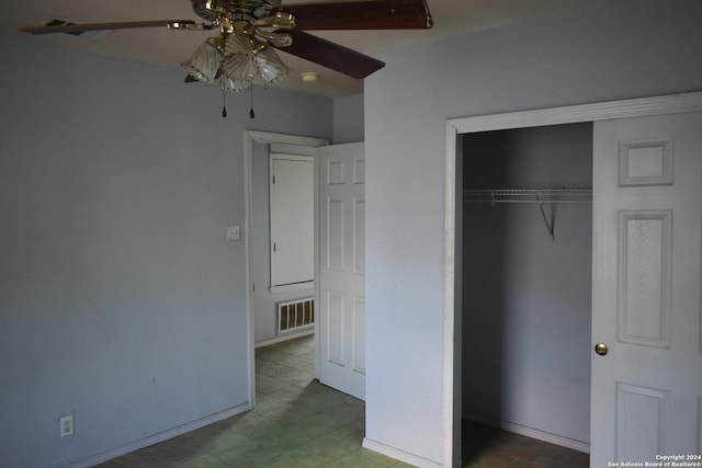 unfurnished bedroom with ceiling fan and a closet