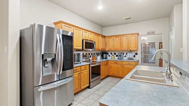 kitchen with light tile patterned flooring, stainless steel appliances, and sink