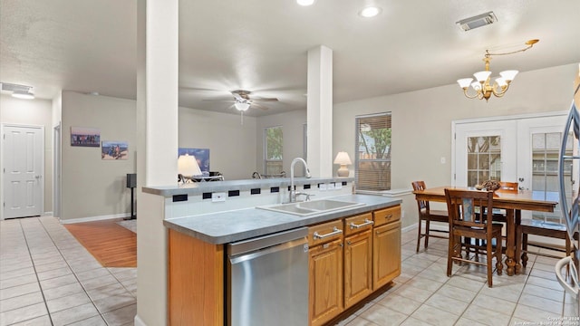 kitchen with ceiling fan with notable chandelier, sink, pendant lighting, dishwasher, and light tile patterned flooring