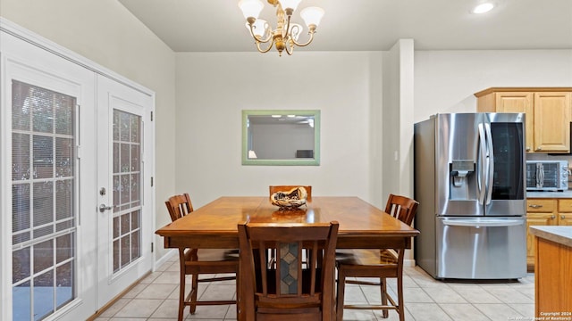 dining space featuring french doors, light tile patterned floors, and a notable chandelier