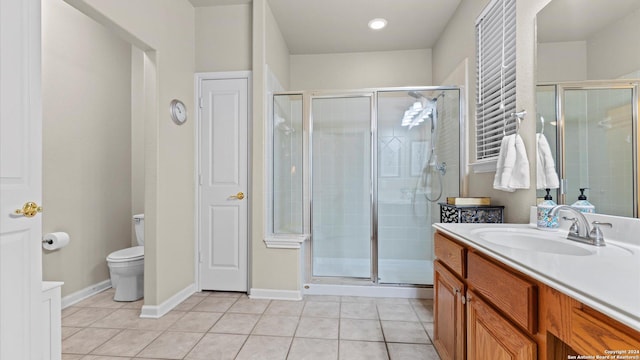 bathroom featuring tile patterned flooring, vanity, a shower with shower door, and toilet