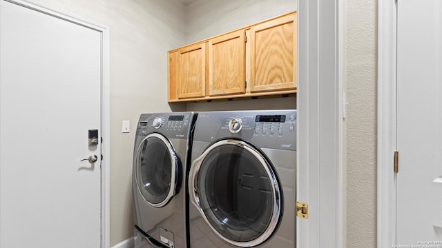 laundry area featuring cabinets and washer and clothes dryer