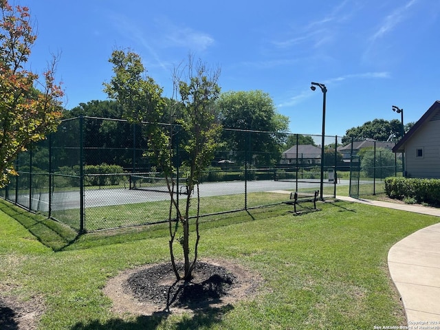 view of sport court with a yard