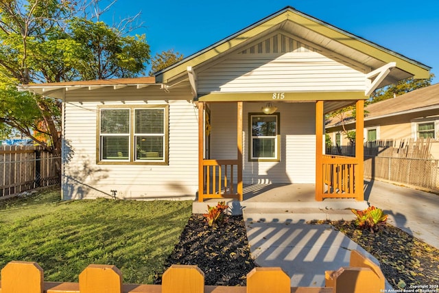 bungalow-style home with a front yard and a porch