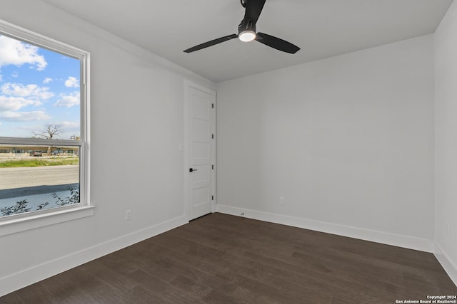 empty room featuring ceiling fan, dark hardwood / wood-style flooring, and a wealth of natural light