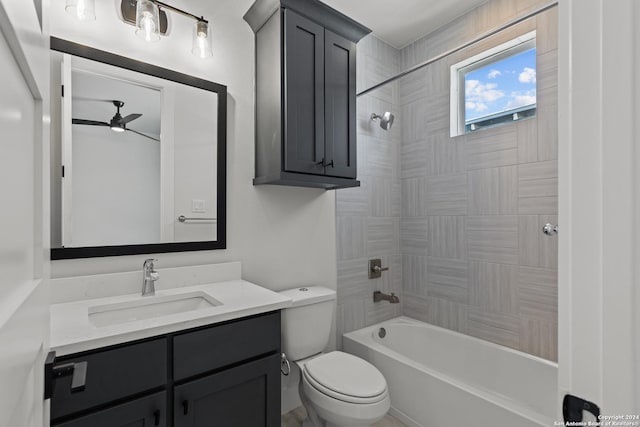 full bathroom featuring ceiling fan, toilet, tiled shower / bath, and vanity