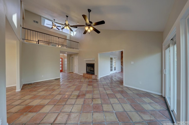 unfurnished living room with ceiling fan, light tile patterned flooring, and high vaulted ceiling