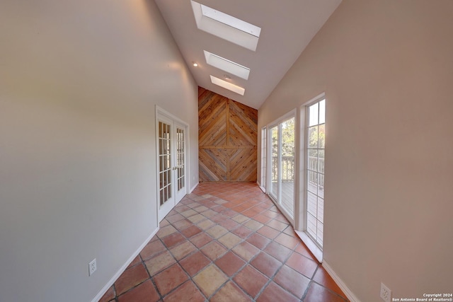 interior space featuring vaulted ceiling with skylight and french doors