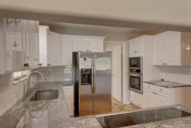 kitchen with decorative backsplash, stainless steel appliances, white cabinetry, and sink