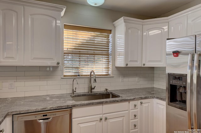 kitchen with decorative backsplash, stainless steel appliances, white cabinetry, and sink