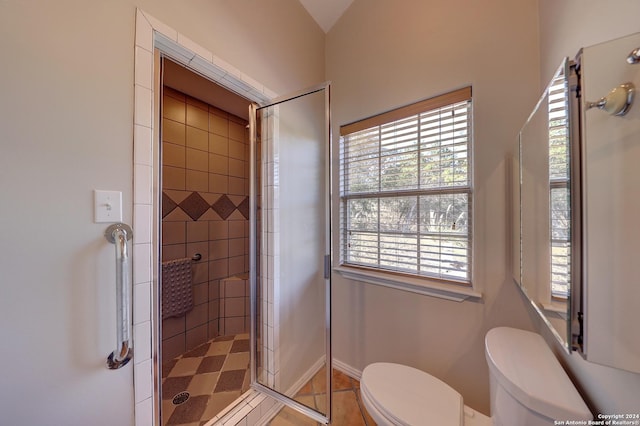 bathroom featuring tile patterned floors, toilet, and an enclosed shower