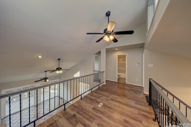 hall with hardwood / wood-style floors and vaulted ceiling