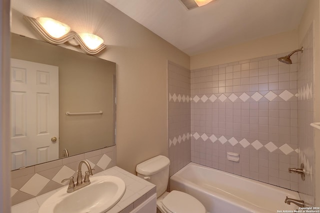 full bathroom with vanity, decorative backsplash, tiled shower / bath, and toilet