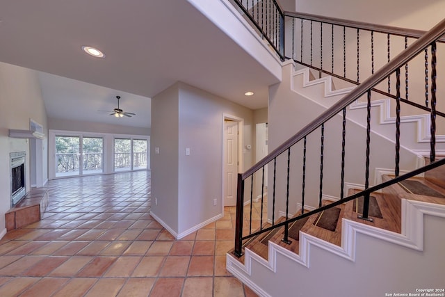 staircase featuring tile patterned floors, ceiling fan, and vaulted ceiling