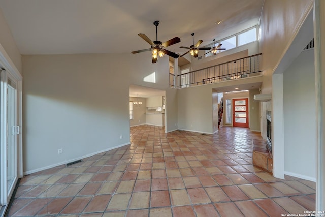 unfurnished living room featuring ceiling fan, light tile patterned flooring, and high vaulted ceiling