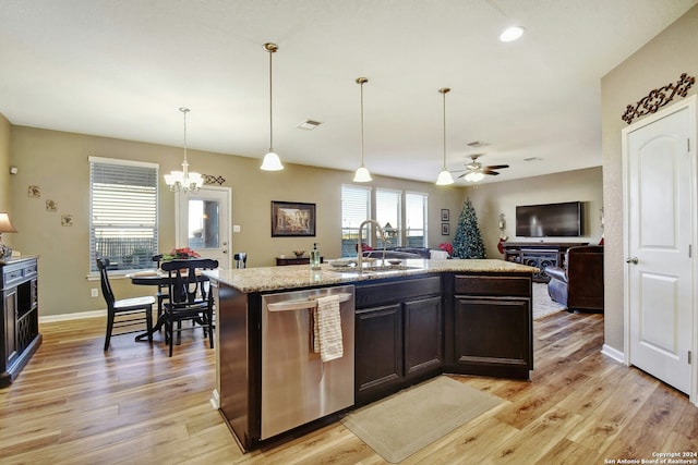 kitchen featuring stainless steel dishwasher, ceiling fan with notable chandelier, sink, a center island with sink, and light hardwood / wood-style floors