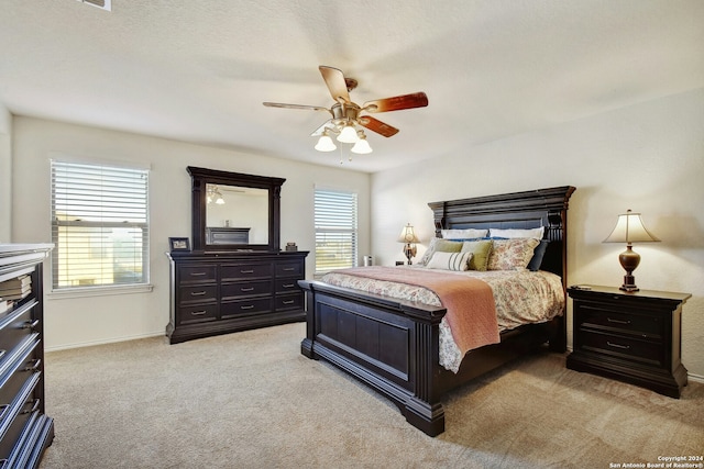 carpeted bedroom with multiple windows, ceiling fan, and a textured ceiling