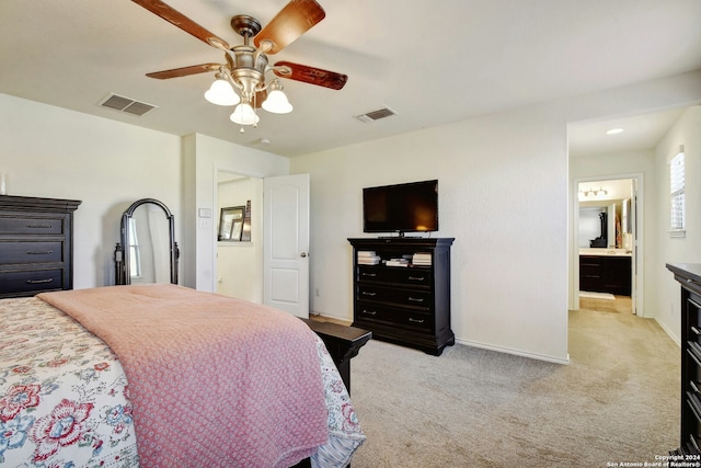 carpeted bedroom featuring ceiling fan and ensuite bath