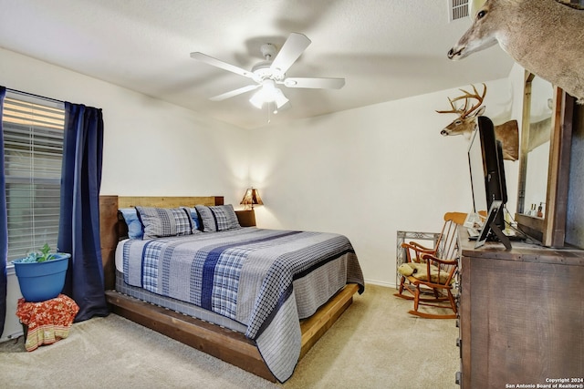 bedroom with ceiling fan and light carpet