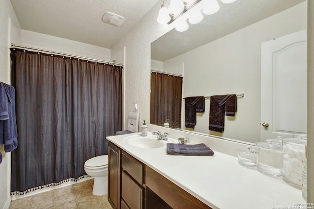 bathroom with tile patterned floors, vanity, a textured ceiling, and toilet