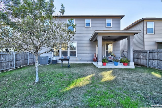 back of house featuring a yard, central AC, and a patio area