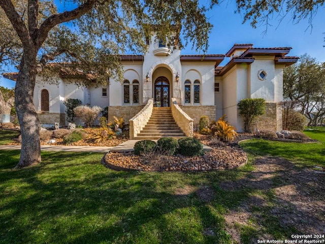 mediterranean / spanish house with french doors and a front yard