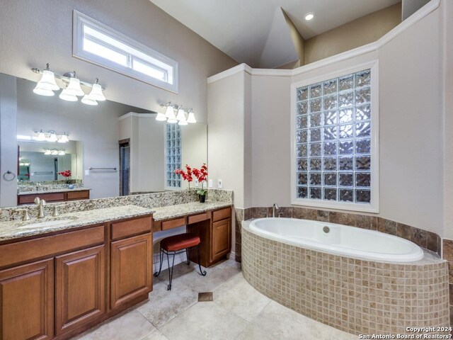 bathroom with tile patterned flooring, a garden tub, and vanity