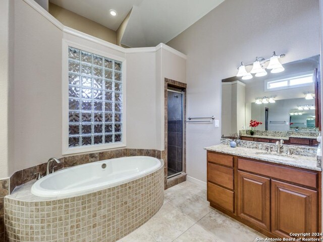 bathroom with a stall shower, tile patterned flooring, a bath, and vanity