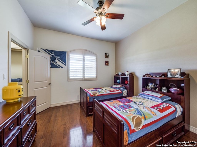 bedroom featuring baseboards, dark wood finished floors, and a ceiling fan