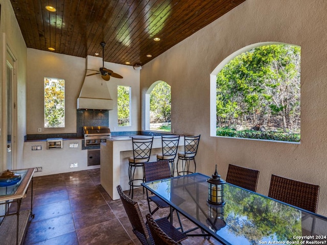 exterior space with recessed lighting, wood ceiling, ceiling fan, and a textured wall