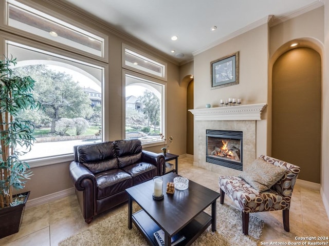 living room with light tile patterned floors, baseboards, a fireplace, and ornamental molding