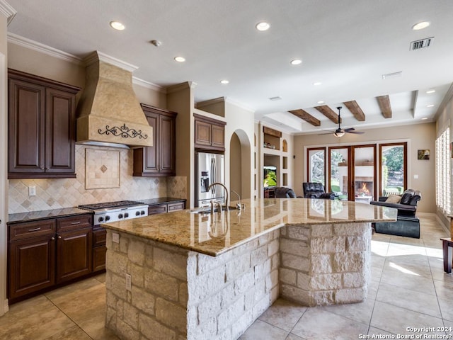 kitchen featuring open floor plan, stainless steel appliances, a spacious island, and custom exhaust hood