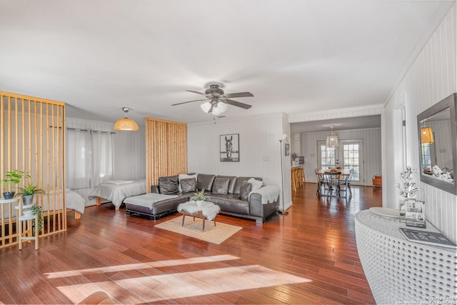 living room featuring wood-type flooring, ceiling fan, and ornamental molding