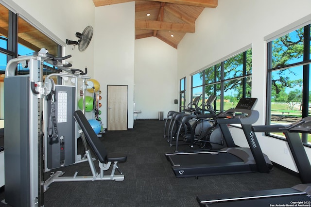 exercise room with high vaulted ceiling and wooden ceiling