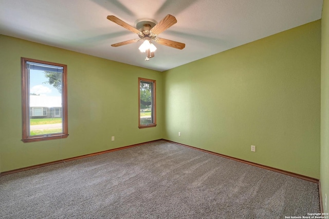 empty room featuring carpet, ceiling fan, and a healthy amount of sunlight