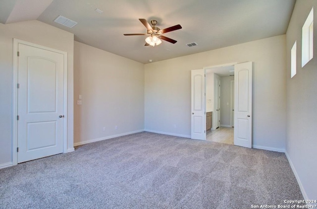 unfurnished bedroom with light carpet, vaulted ceiling, and ceiling fan